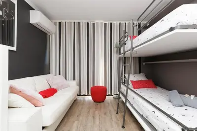 a bedroom with two bunk beds and a red stool at Vue mer piscine parking tennis 4 personnes in Cannes