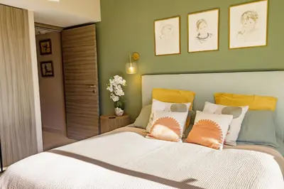 a bedroom with a large bed with orange and white pillows at Villa Lerins 411 by Halldis in Cannes