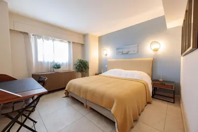 a bedroom with a bed and a table and a desk at Villa Lerins 411 by Halldis in Cannes