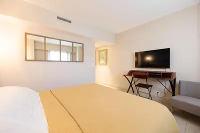 a bedroom with a bed and a desk and a television at Villa Lerins 411 by Halldis in Cannes