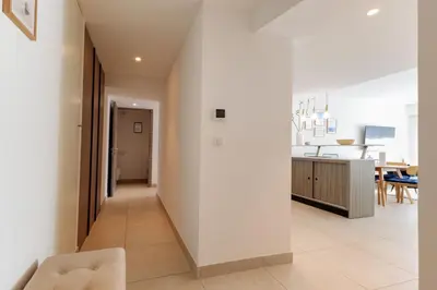 a living room with white walls and a kitchen at Villa Lerins 304 by Halldis in Cannes