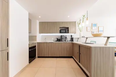 a kitchen with white walls and wooden cabinets at Villa Lerins 304 by Halldis in Cannes