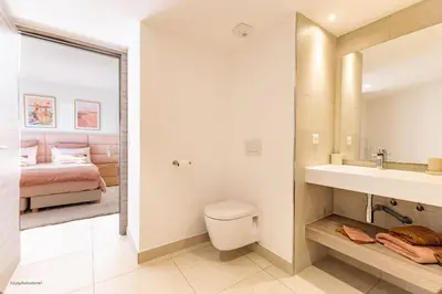 a bathroom with a toilet and a sink and a bed at Villa Lerins 304 by Halldis in Cannes
