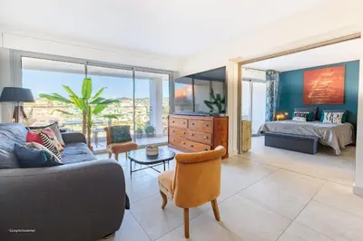 a living room with a couch and a bedroom at Villa Lerins 405 by Halldis in Cannes