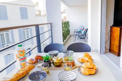 a table with bread and pastries on a balcony at Villa Lerins 405 by Halldis in Cannes