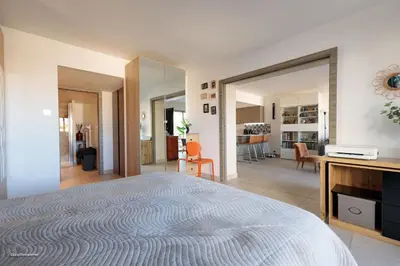a bedroom with a large bed and a living room at Villa Lerins 405 by Halldis in Cannes