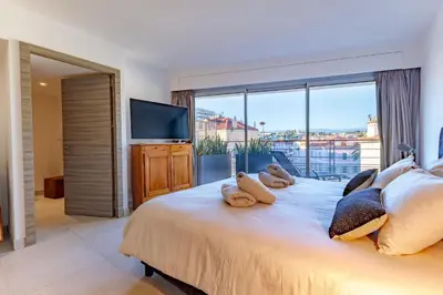 a bedroom with a large bed with a large window at Villa Lerins 401 by Halldis in Cannes