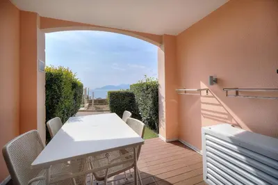 a house with a garden with a table and chairs at Vue Mer - Piscine - Tennis - 2P avec Jardin - Cannes in Cannes