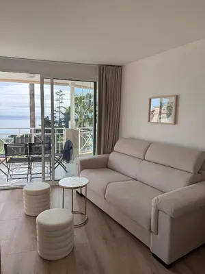 a living room with a couch and a table at CasaMia Cannes - Exceptional Sea View, Pool, Beach in Cannes