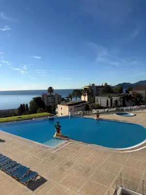 a large swimming pool with a view of the ocean at CasaMia Cannes - Exceptional Sea View, Pool, Beach in Cannes