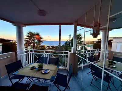 a balcony with a table and chairs and the ocean at CasaMia Cannes - Exceptional Sea View, Pool, Beach in Cannes