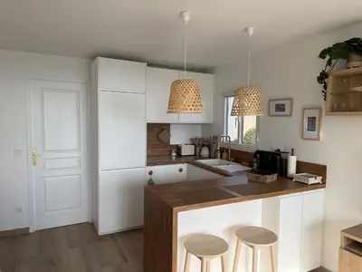 a kitchen with white cabinets and a counter with stools at CasaMia Cannes - Exceptional Sea View, Pool, Beach in Cannes