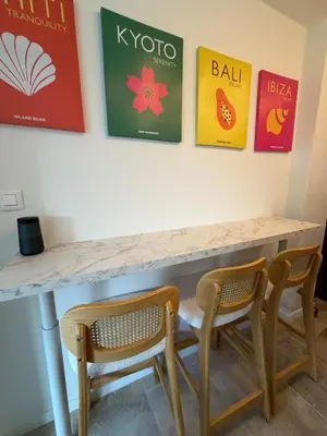 a table with two chairs and posters on the wall at Charming studio 2 min from beach in La Celle-sous-Gouzon