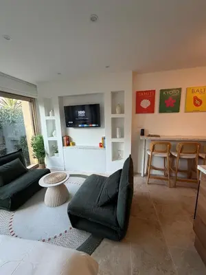 a living room with a couch and a table at Charming studio 2 min from beach in La Celle-sous-Gouzon
