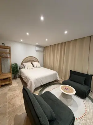a bedroom with a bed and a couch and a table at Charming studio 2 min from beach in La Celle-sous-Gouzon