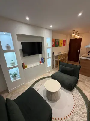 a living room with two couches and a table at Charming studio 2 min from beach in La Celle-sous-Gouzon