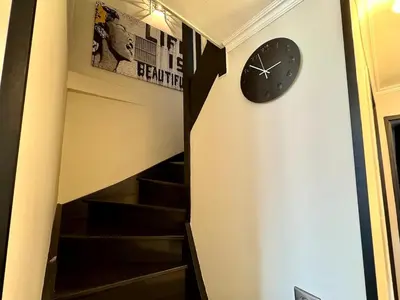 a clock on a wall next to some stairs at Appart 3 chambres, Cannes centre & plages in Cannes