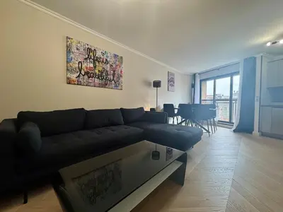 a living room with a black couch and a table at Appart 3 chambres, Cannes centre & plages in Cannes