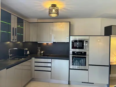 a kitchen with white cabinets and a microwave at Appart 3 chambres, Cannes centre & plages in Cannes