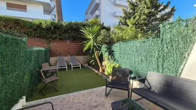 a backyard with chairs and a fence and a lawn at Croisette, studio with garden, air conditioning in Cannes