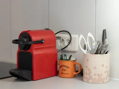a red toaster sitting on a counter next to a cup at Croisette, studio with garden, air conditioning in Cannes