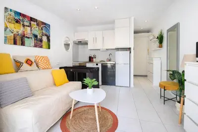 a living room with a white couch and a table at Croisette, studio with garden, air conditioning in Cannes