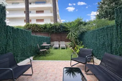 a garden with chairs and a table and a building at Croisette, studio with garden, air conditioning in Cannes