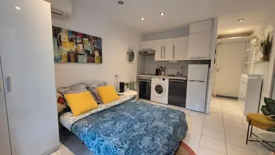 a living room with a couch and a kitchen at Croisette, studio with garden, air conditioning in Cannes