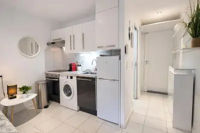a kitchen with a white refrigerator and a dishwasher at Croisette, studio with garden, air conditioning in Cannes