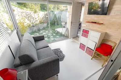 a living room with a couch and a tv at Private Garden Hideaway by the Sea in Cannes
