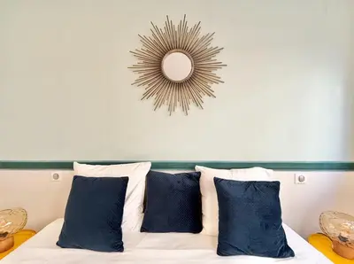 a bed with blue pillows and a mirror above it at Cannes One bedroom Apartment - M10 in Cannes