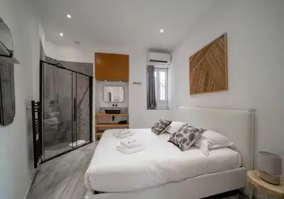 a white bedroom with a large white bed in it at Parenthèse élégante au centre de Cannes in Cannes