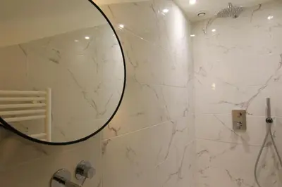 a bathroom with a shower with a mirror at Pearl Studio by Halldis in Cannes