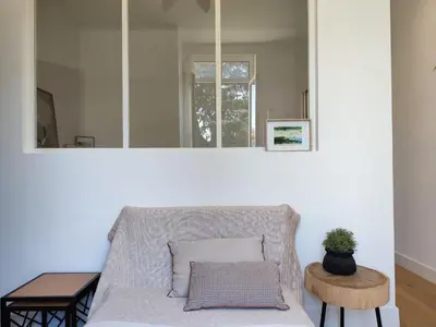 a living room with a couch and a mirror at Pearl Studio by Halldis in Cannes