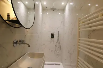 a bathroom with a sink and a shower with a mirror at Pearl Studio by Halldis in Cannes