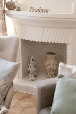 a living room with a fireplace with vases and a couch at Écrin de charme à 2 pas de la Croisette & Palais in Cannes