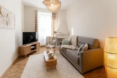a living room with a couch and a tv at Écrin de charme à 2 pas de la Croisette & Palais in Cannes