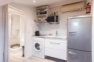 a kitchen with a refrigerator and a washing machine at Studio Meynadier by Halldis in Cannes