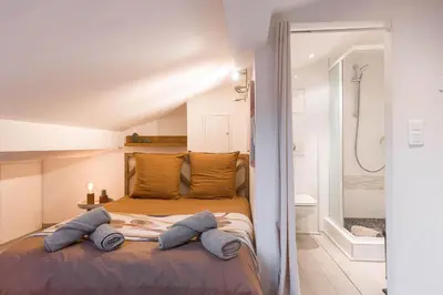 a bedroom with a bed with two pillows and a shower at Studio Meynadier by Halldis in Cannes