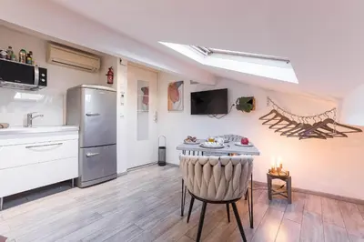 a kitchen with a sink and a table with a chair at Studio Meynadier by Halldis in Cannes