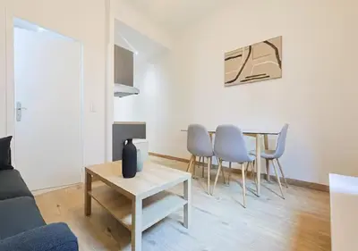 a living room with a table and chairs at Charmant deux pièces au Suquet in Cannes