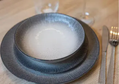 a black plate sitting on top of a table at Charmant deux pièces au Suquet in Cannes