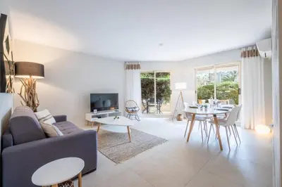 a living room with a couch and a table at 3P Garden-Level Apartment in a Residence with Pool Close to the Center in Cannes
