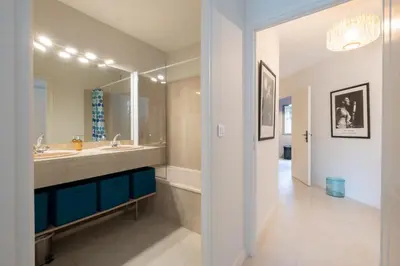 a bathroom with a sink and a large mirror at 3P Garden-Level Apartment in a Residence with Pool Close to the Center in Cannes