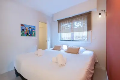 a bedroom with a large white bed with two pillows at 3P Garden-Level Apartment in a Residence with Pool Close to the Center in Cannes