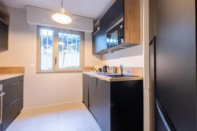 a kitchen with a sink and a window at 3P Garden-Level Apartment in a Residence with Pool Close to the Center in Cannes