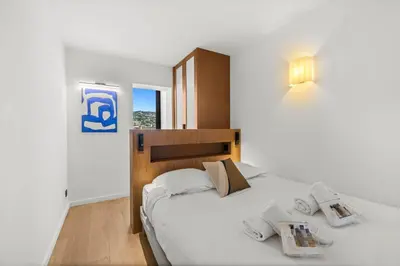 a bedroom with a large white bed with two pillows at REF 2030 - Cannes Croisette - Sea view apartment for rent in Cannes