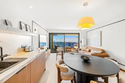 a kitchen and living room with a table and a sink at REF 2030 - Cannes Croisette - Sea view apartment for rent in Cannes
