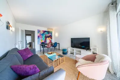 a living room with a couch and a tv at Spacious 1-bedroom apartment in the heart of Cannes in Cannes