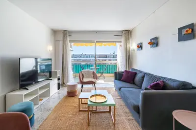 a living room with a blue couch and a tv at Spacious 1-bedroom apartment in the heart of Cannes in Cannes